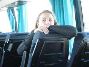 Agnieszka schaut über einen Sitz im Bus.