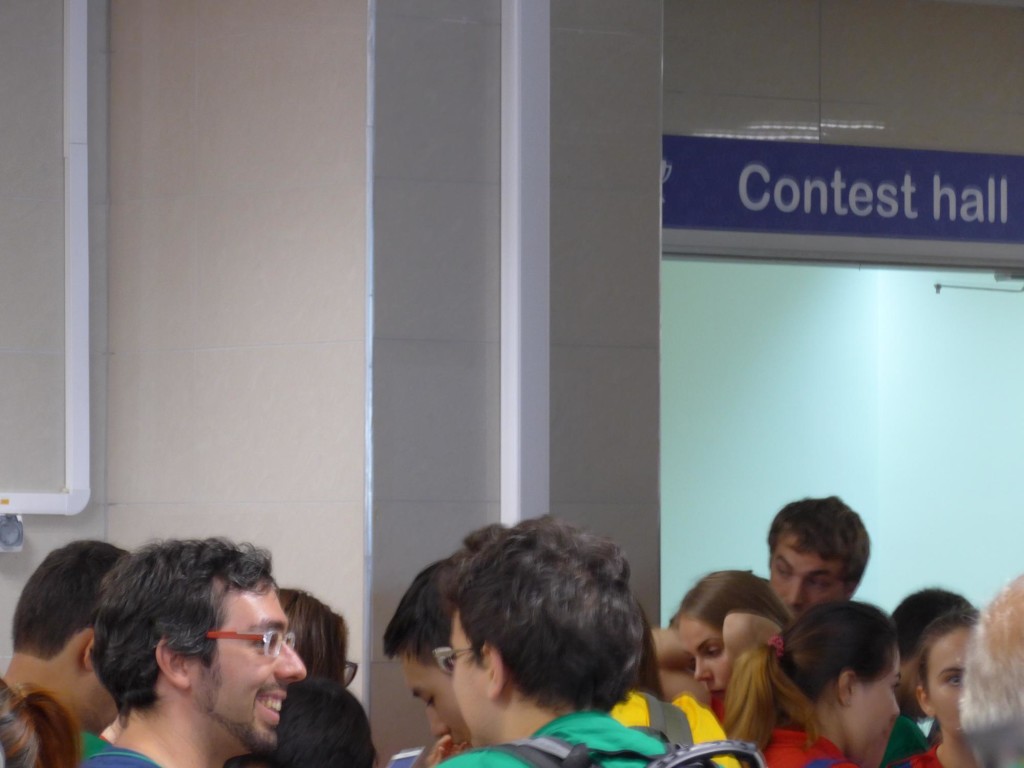 A crowd in front of the contest hall (labelled as such by a sign)