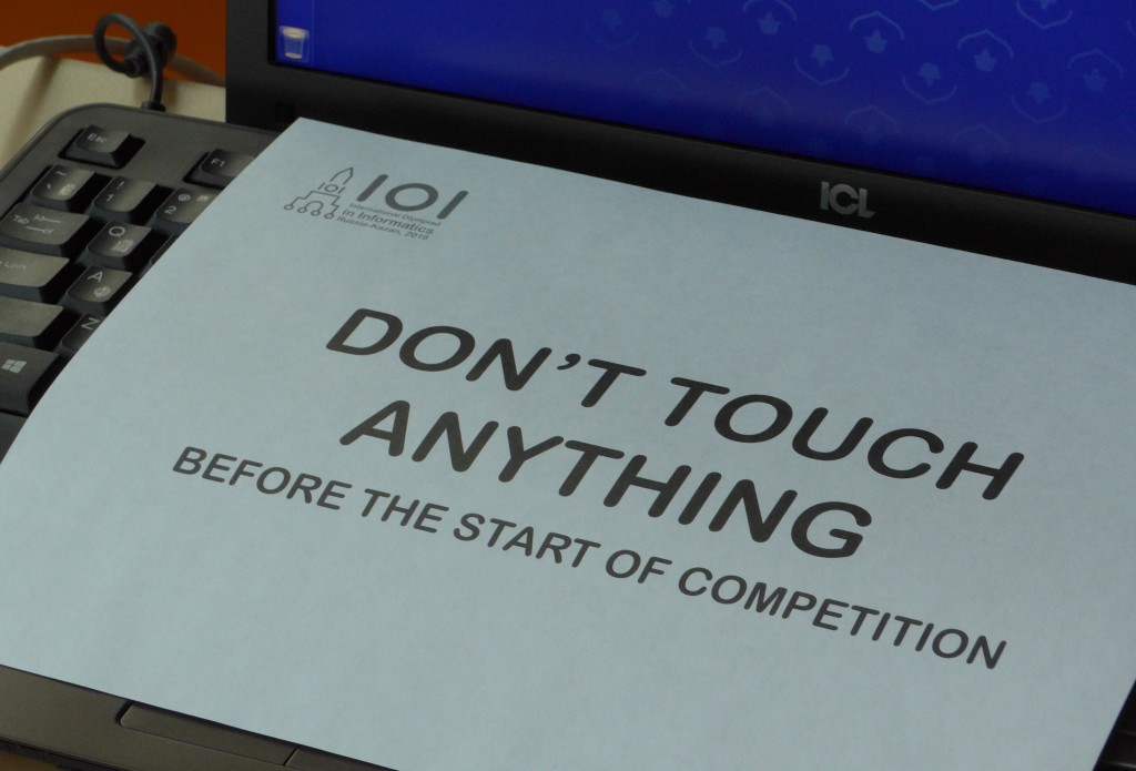 Papier mit der Aufschrift „DON’T TOUCH ANYTHING BEFORE THE START OF COMPETITION“ auf einem Laptop